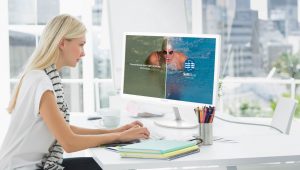 Casual young woman using computer in office